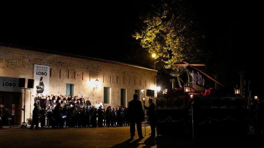 El coro de hermandad, al fondo, y la imagen de Jesús en su Tercera Caída en la plaza de la Catedral.