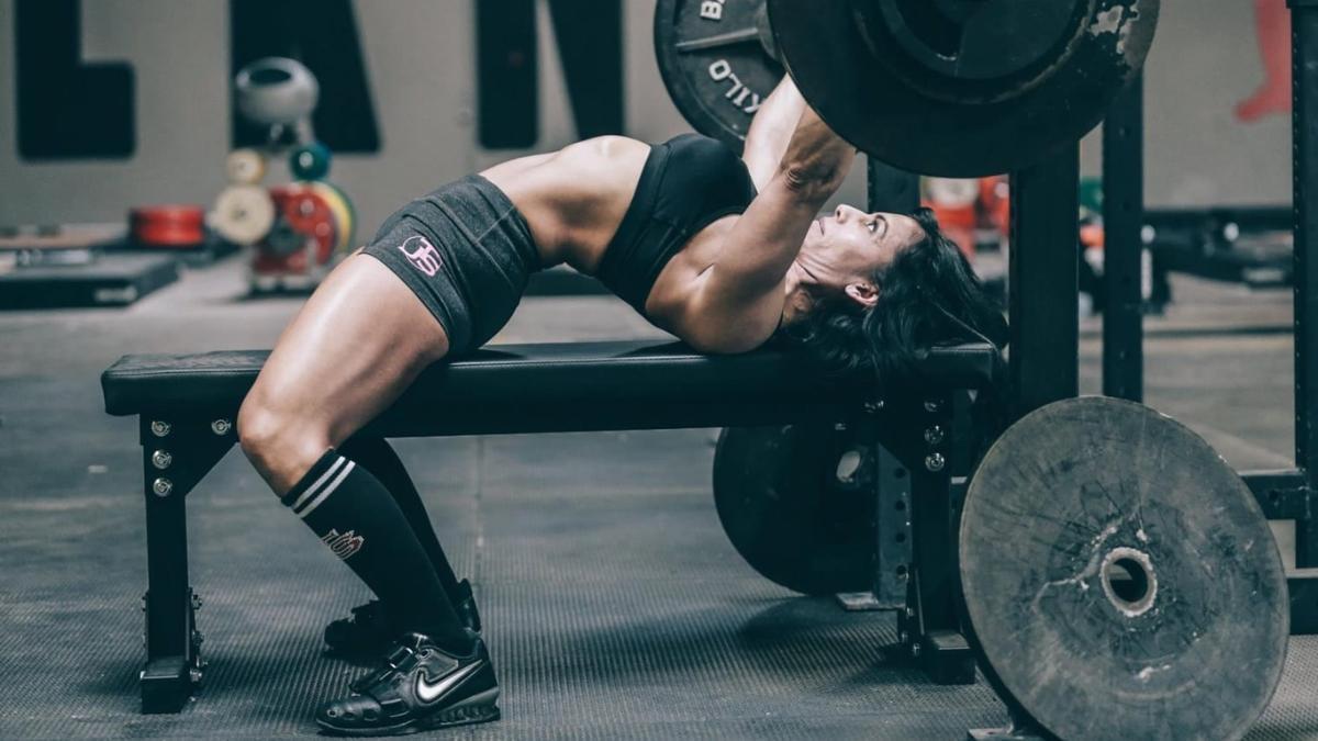 Una mujer realizando un ejercicio de peso en el gimnasio