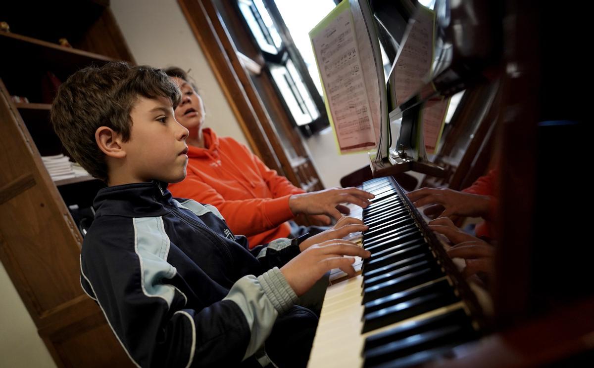 Guille, de 9 años, aprende a tocar el piano durante su primer año en la Escolanía.