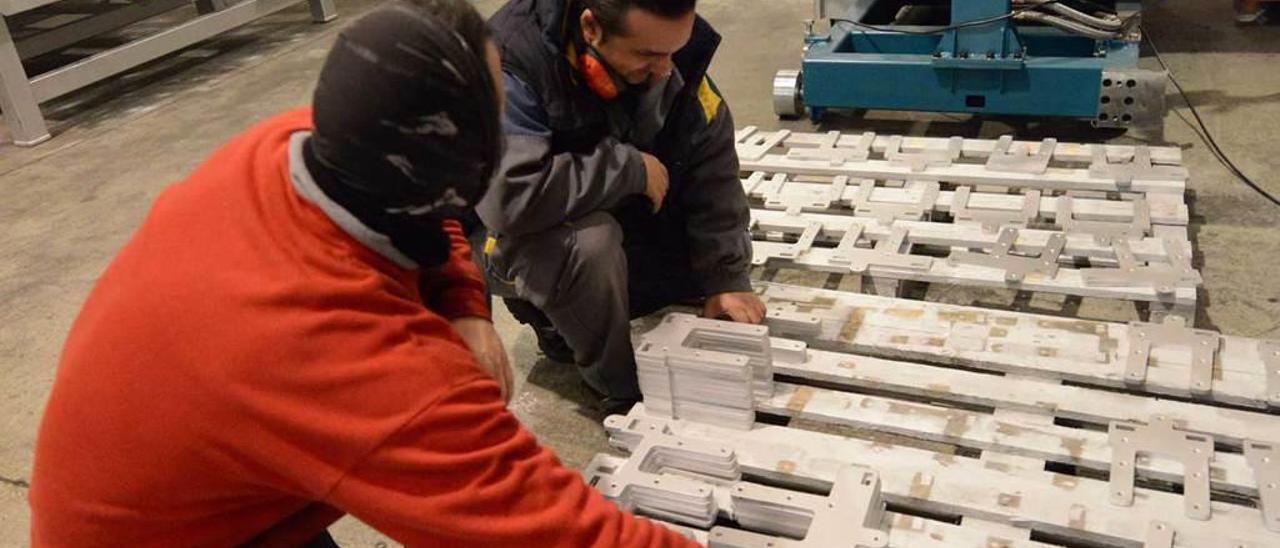 A la izquierda, empleados haciendo unas pruebas entre la mercancía. A la derecha, un trabajador mide una pieza, después de que se precintara ya una parte de la factoría.