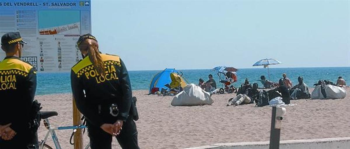 Vigilància8 Dos policies locals del Vendrell vigilen un grup de manters que hi ha a la sorra de la platja, dijous.