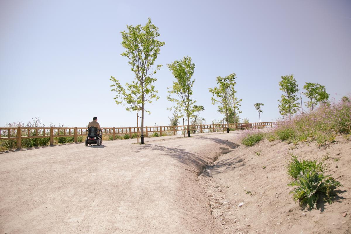 Javier Font sube una cuesta del parque de La Gavia con su silla de ruedas eléctrica.