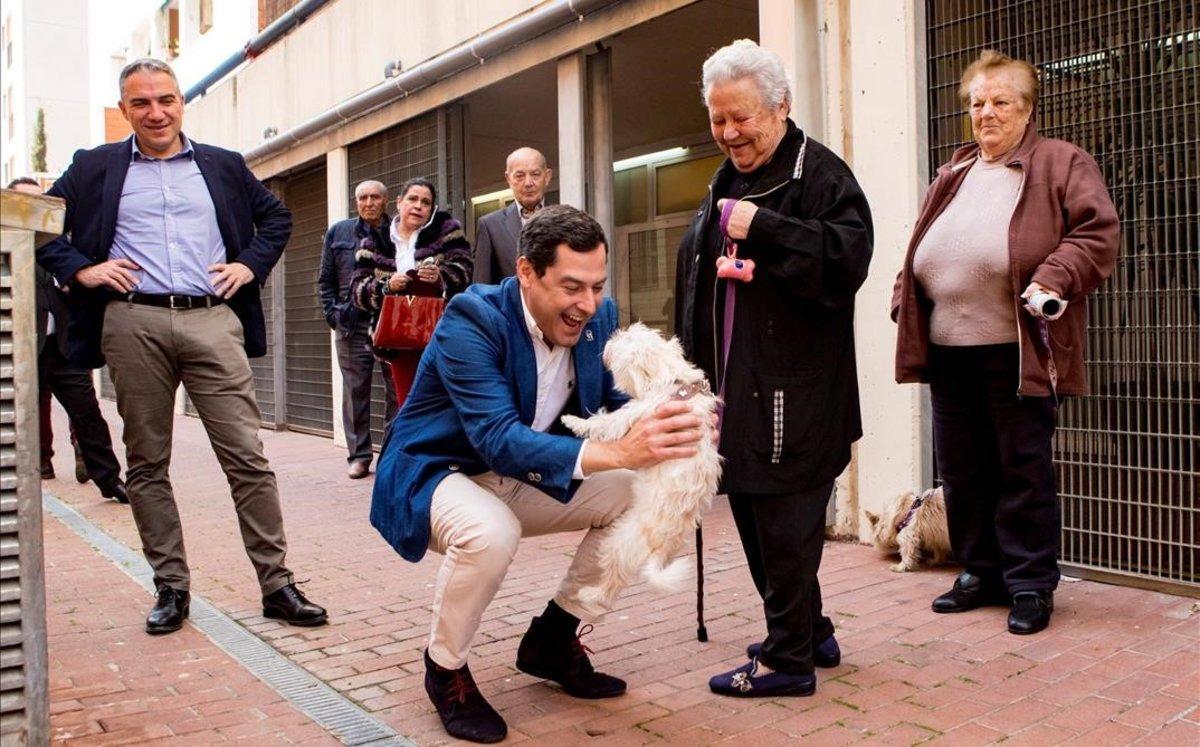 El presidente de la Junta de Andalucía, Juanma Moreno, saluda a dos vecinas del barrio de Verdum, en Barcelona.