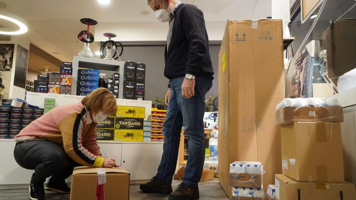 Dos personas ayudan a empaquetar productos que Ángel y Julián transportan para los ucranianos.