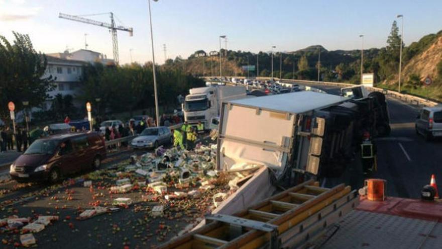 El camión, volcado sobre la autovía con toda la carga sobre el asfalto.