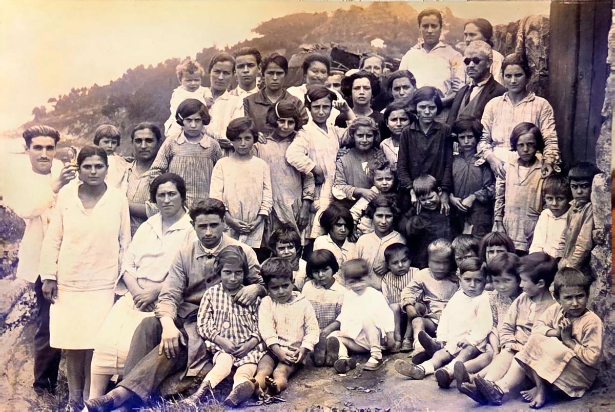 José Rivera Fernández, el cuarto por la izquierda y hacia abajo, abrazando a una niña, con gente del barrio.