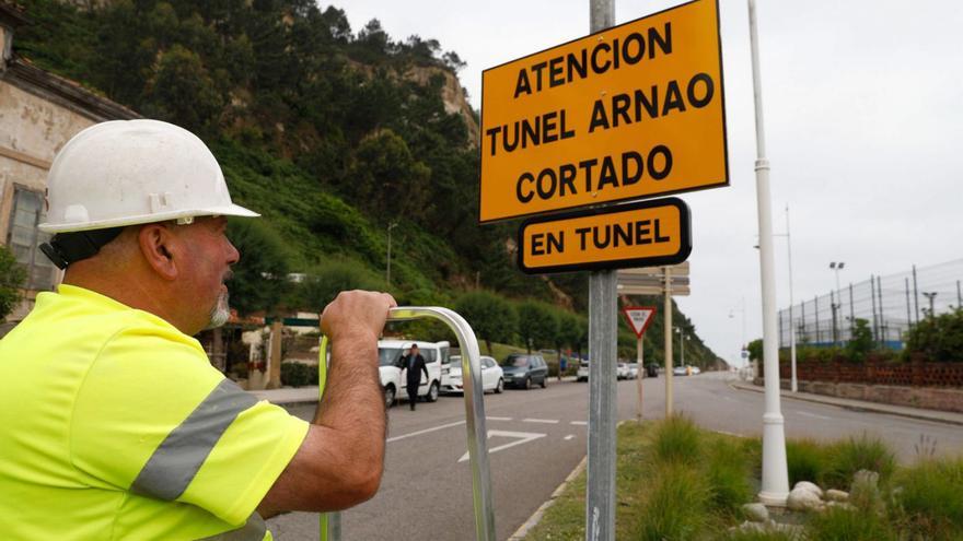 Un operario, ante el cartel de las obras del túnel de Arnao. | Mara Villamuza