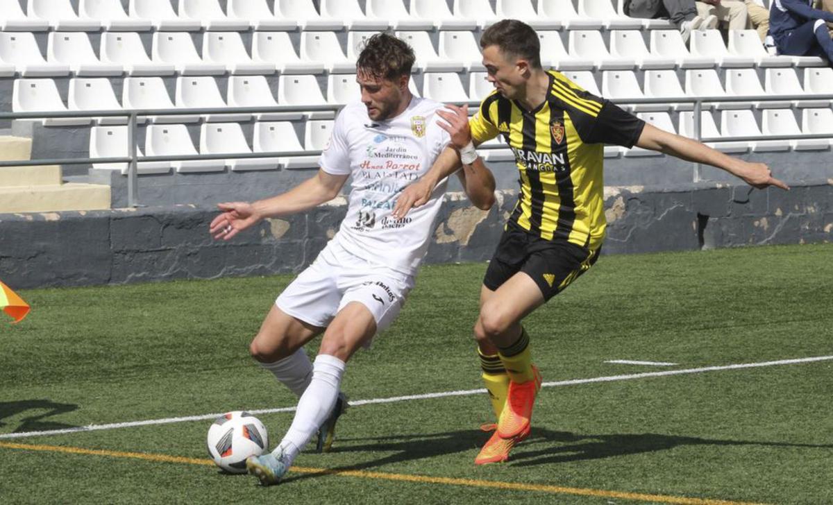 Samu Vázquez avanza con el balón por la banda ante el acoso de un rival.