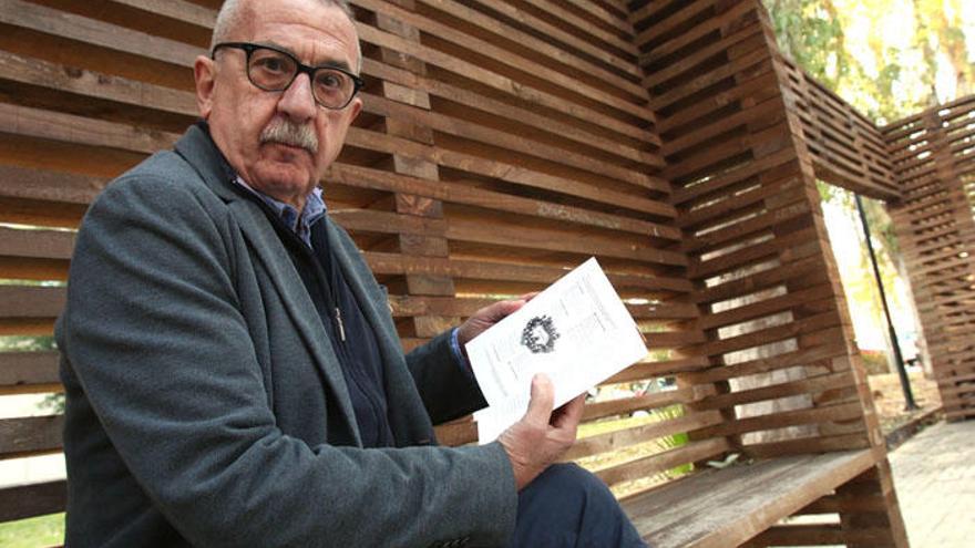 Carlos Hernández Pezzi sostiene su último libro mientras posa para el fotógrafo.