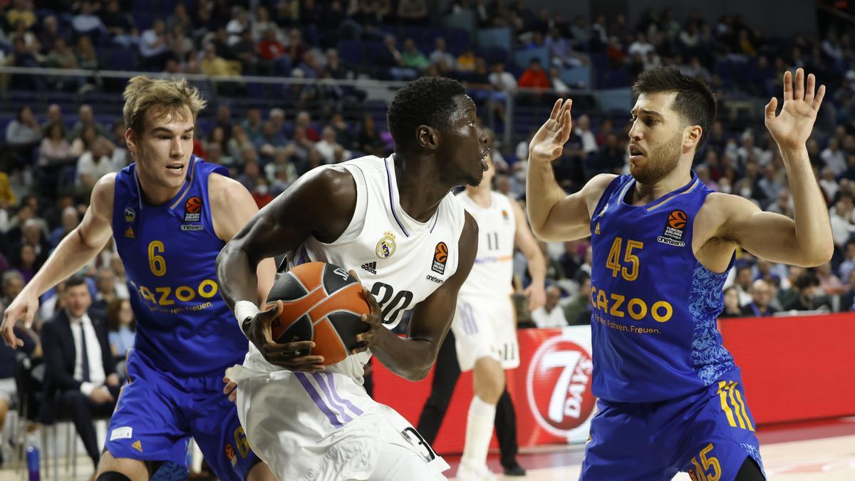 El pívot del Real Madrid Eli Ndiaye con le balón ante el escolta estadounidense del Alba Berlin Tamir Blatt.