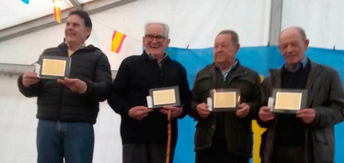 Por la derecha José Luis Tielve, Rufo Menéndez y Ángel Obeso, junto al representante de Ramón Gay, recogen las placas durante el homenaje.