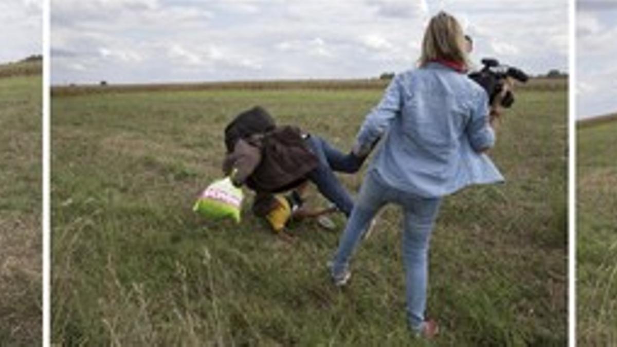 Petra Laszlo le hace la zancadilla a un padre que lleva en brazos a su hijo y una bolsa con sus pertenencias, en Roszke (Hungría).