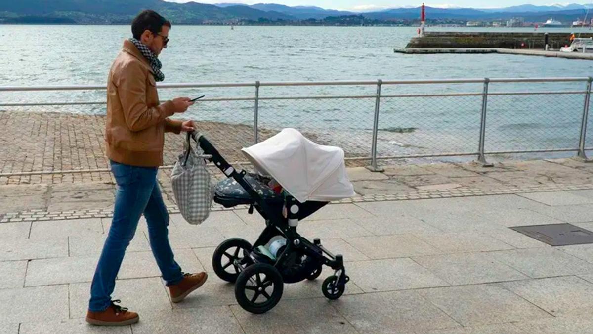 Un padre paseando a un bebé.