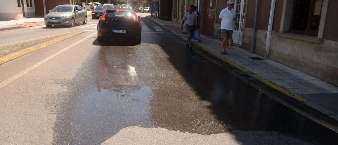 Otra deficiencia en la red municipal de agua puede observarse en la avenida Rosalía de Castro, concretamente en el tramo comprendido entre la sede del Gato Negro y la rotonda de la Praza da Liberdade, en Carril. Se trata de una fuga de agua limpia baja por la carretera desde hace varios días. Las canalizaciones más antiguas suelen dar problemas, sobre todo en la época estival, con un repunte de población y también de consumo de agua. | NOÉ PARGA