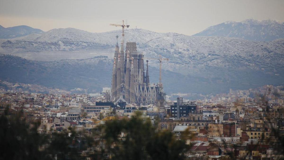 La ciudad de Barcelona, rodeada de nieve en las montañas. En primer plano, la Sagrada Família