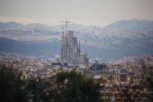 La ciudad de Barcelona, rodeada de nieve en las montañas. En primer plano, la Sagrada Família.