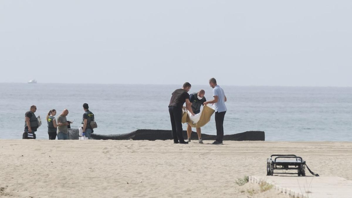 Agentes de la Guardia Civil, junto al cuerpo de la recién nacida, en la playa Costa Daurada (Tarragona).   EFE/Quique García