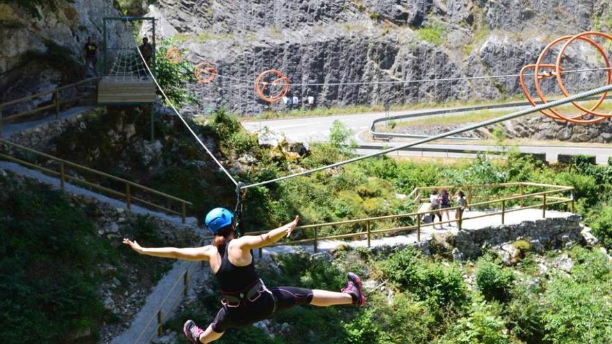 Una visitante se lanza por una de las tirolinas del campo multiaventura de Puente Vidosa.