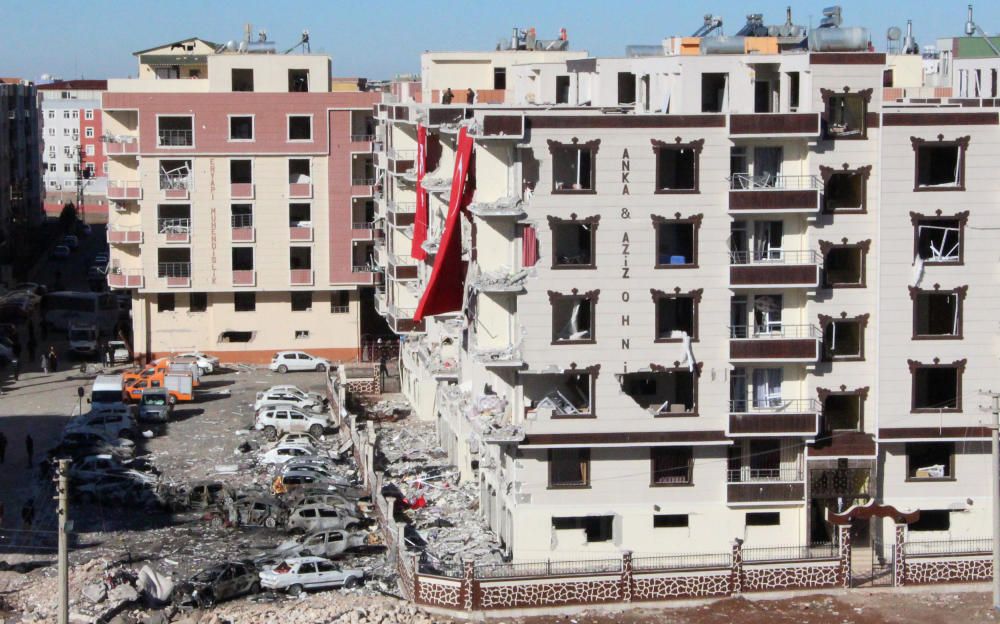 Coches y edificios dañados después de la explosión del viernes en un complejo de viviendas en Turquía, cerca de la frontera con Siria.