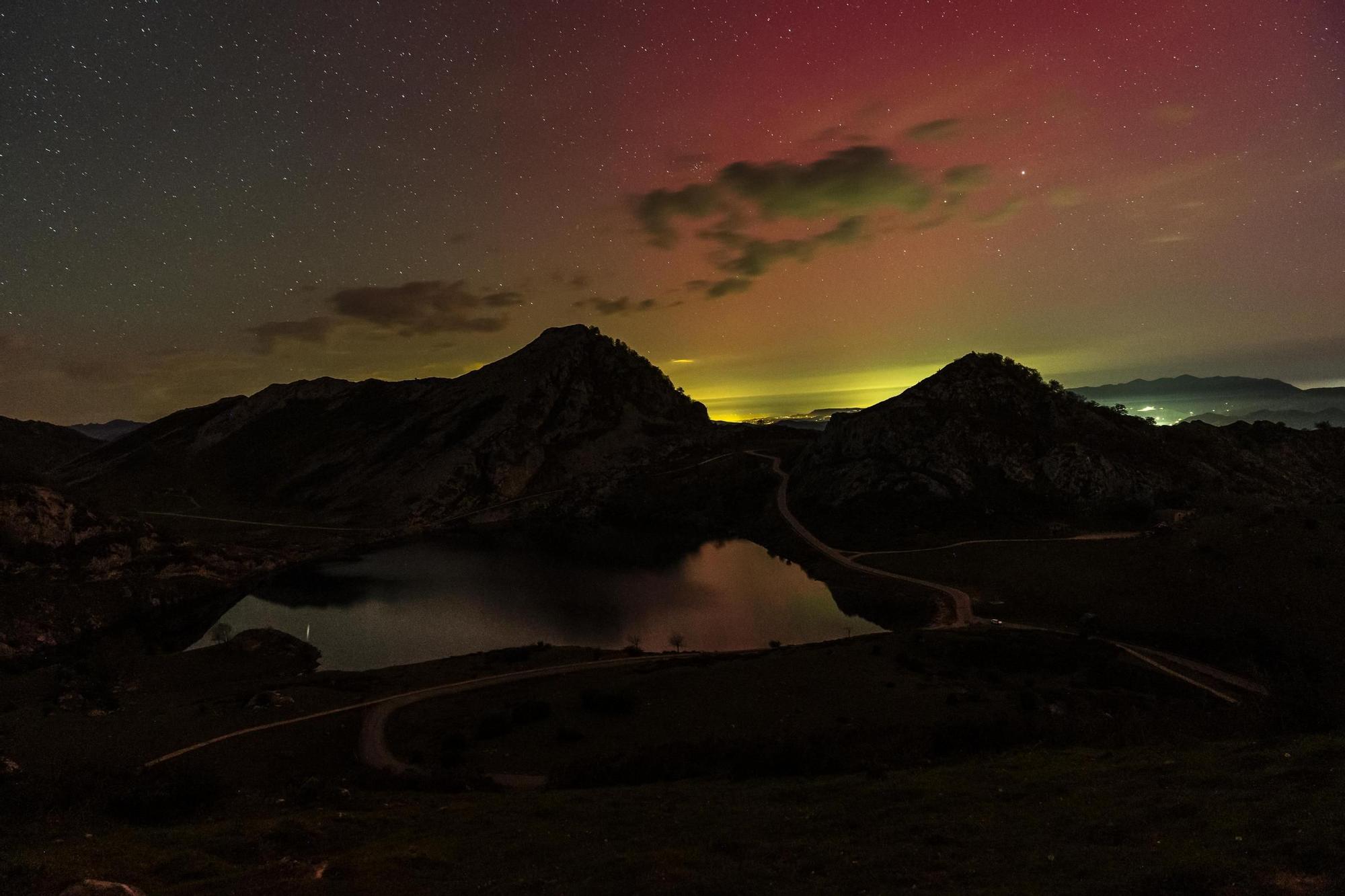 Una panorámica del lago Enol, en los Picos de Europa, con el cielo iluminado por la aurora.