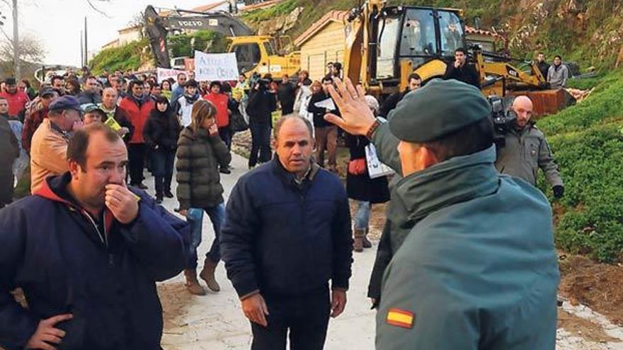 La Guardia Civil dialoga con los vecinos en el lugar donde estaban la maquinaría para el derribo.  // G.N.