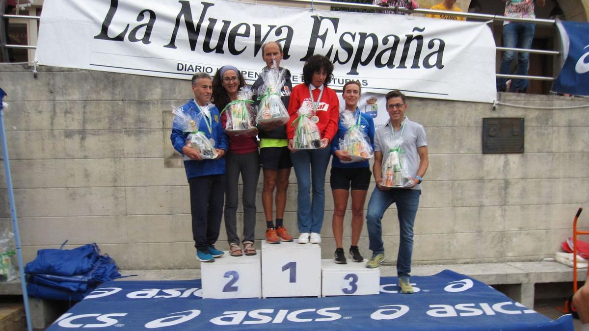 En la imagen de la izquierda, de izquierda a derecha, Mario González, Catalina Balbín, Ciro Canseco, Nela Lois, Naroa Gorría y Víctor González, los ganadores, en el podio. Sobre estas líneas, dos corredores. | LNE