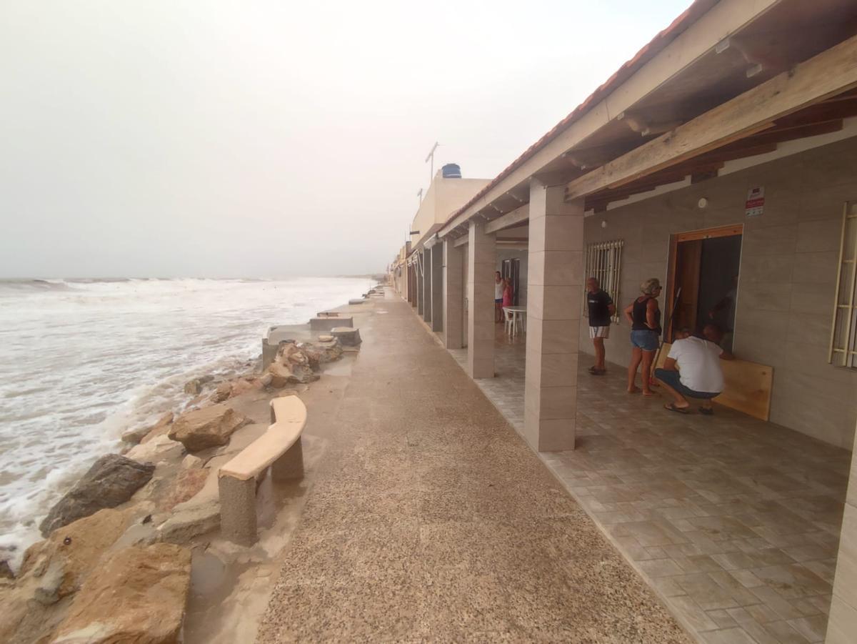 Propietarios de casas en la playa del Pinet de Elche tratando de proteger las viviendas.