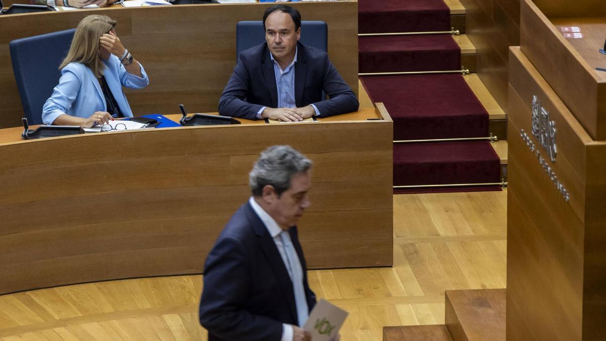 El síndic de Vox, José María Llanos, pasa ante Juanfran Pérez Llorca en el debate de presupuestos, en las Corts.
