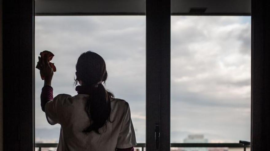 Una mujer limpia un cristal. | LOC