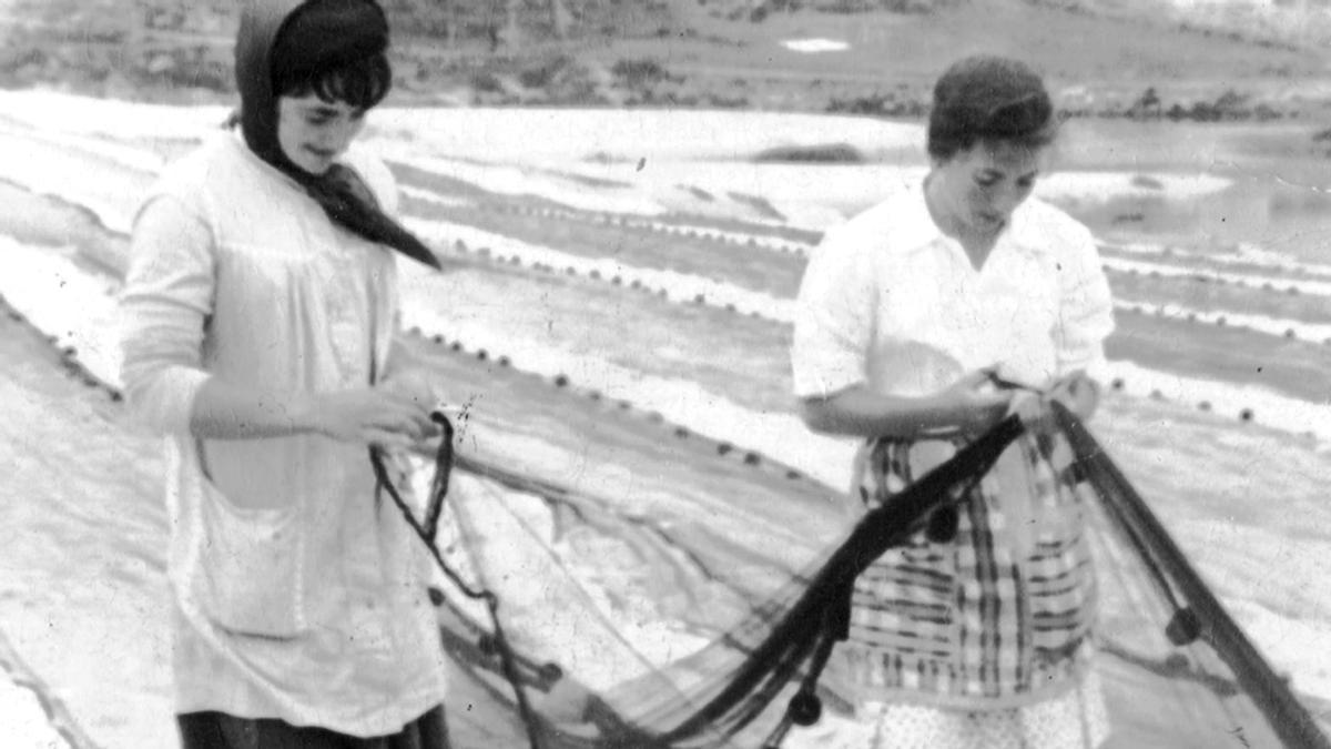 Foto antiga de dúas redeiras arranxando o aparello