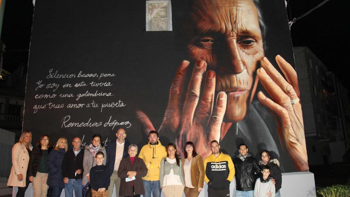 El alcalde de Cártama, Jorge Gallardo, con familiares de Remedios, antes el mural de su vivienda.