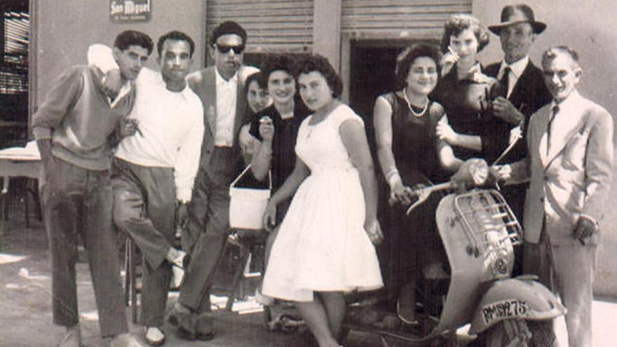 Jóvenes posando en los años sesenta junto a una vespa.