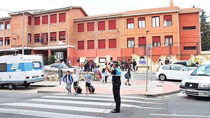 Un agente de la Policía Municipal controla el tráfico a la salida de un colegio en la capital.