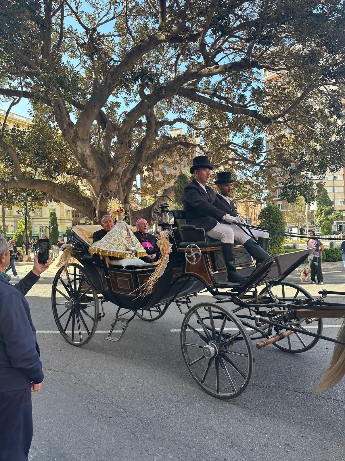 Salida de la Virgen portada por el Perot en la calesa y junto al obispo en dirección al Grau, esta tarde.