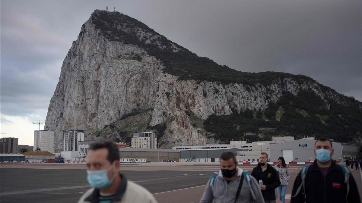 People cross the Spanish border of the British overseas territory of Gibraltar on November 24  2020  - With its traditional British red phone boxes  pubs serving fish-and-chips and tax-free shopping  Gibraltar has long drawn day trippers from neighbouring Spain  But the easy flow of people across the border from Spain which underpins the economy of the tiny British territory on the southern tip of the Iberian Peninsula risks ending when Britain leaves the European Union s single market on December 31  (Photo by JORGE GUERRERO   AFP)