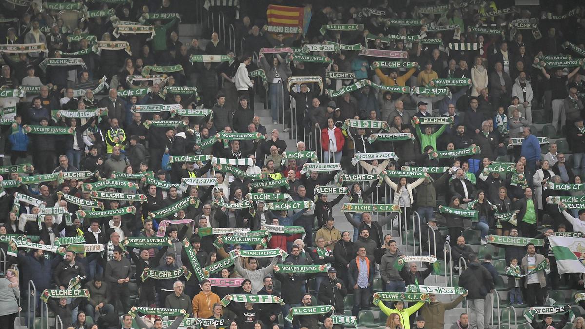 La afición del Elche alza las bufandas durante el último encuentro del conjunto franjiverde.