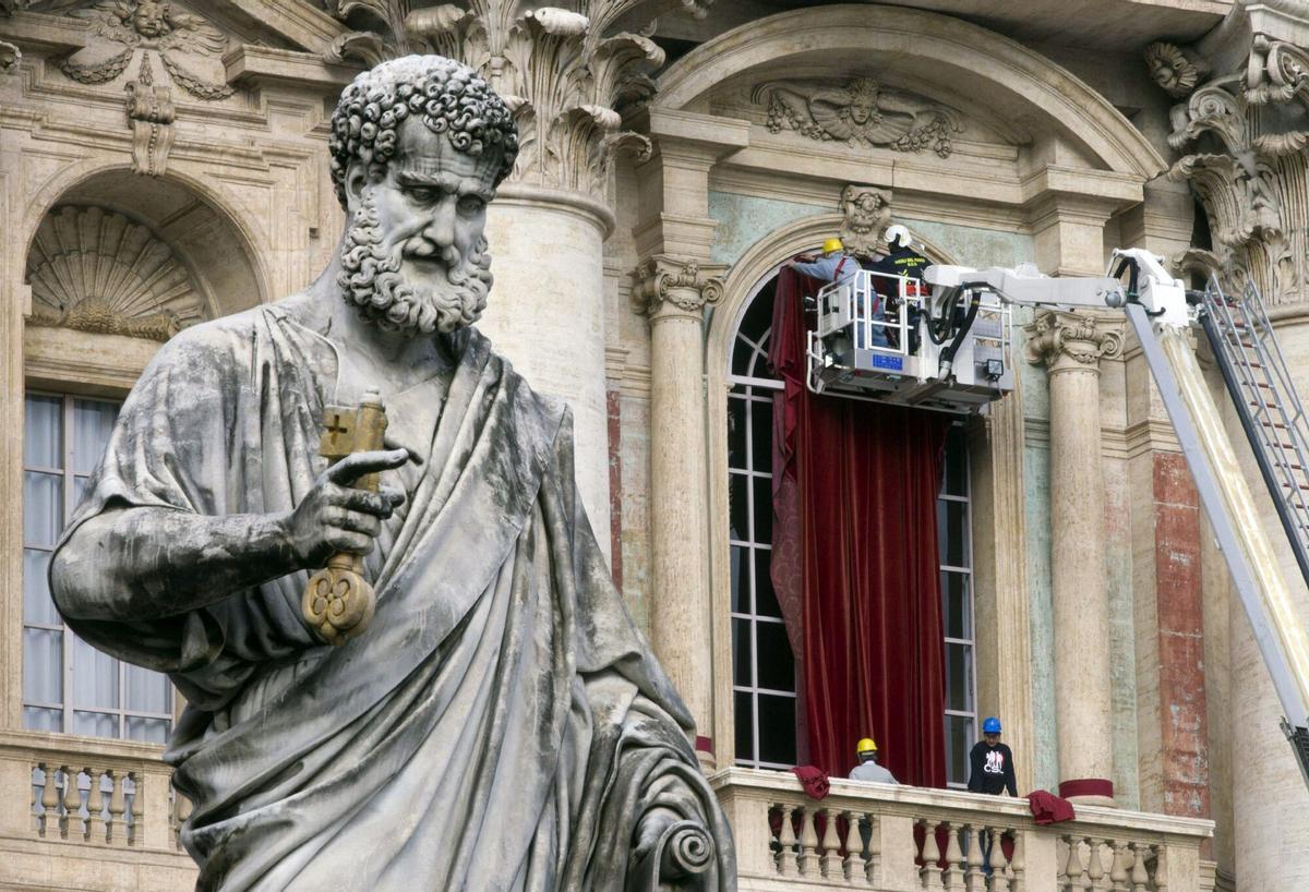 VAT02 VATICANO, 11/03/2013.- Bomberos decoran con terciopelo rojo el balcón central de la Basílica de San Pedro, en la Ciudad del Vaticano, hoy, lunes 11 de marzo de 2013. Los cardenales se reúnen hoy por última vez para preparar el cónclave que comenzará mañana y en el que elegirán al sucesor del papa Benedicto XVI. La décima congregación de cardenales comenzó a las 09.30 horas local (08.30 GMT) en el Aula Nueva del Sínodo, lugar de estas reuniones preparatorias, que comenzaron el lunes 4 de marzo una vez entrada la Iglesia en Sede Vacante tras la renuncia del papa Ratzinger. EFE/Claudio Peri