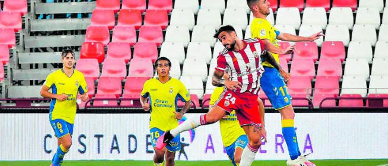 Cristian López, titular ayer por primera vez con la UD, pelea un balón aéreo con David Costas, mientras Fede Varela (16) y Eric Curbelo (6) observan la jugada.