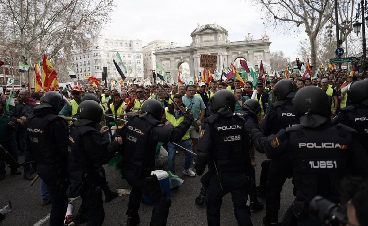 La policía actúa para contener a los agricultores que protestan en la Puerta de Alcalá