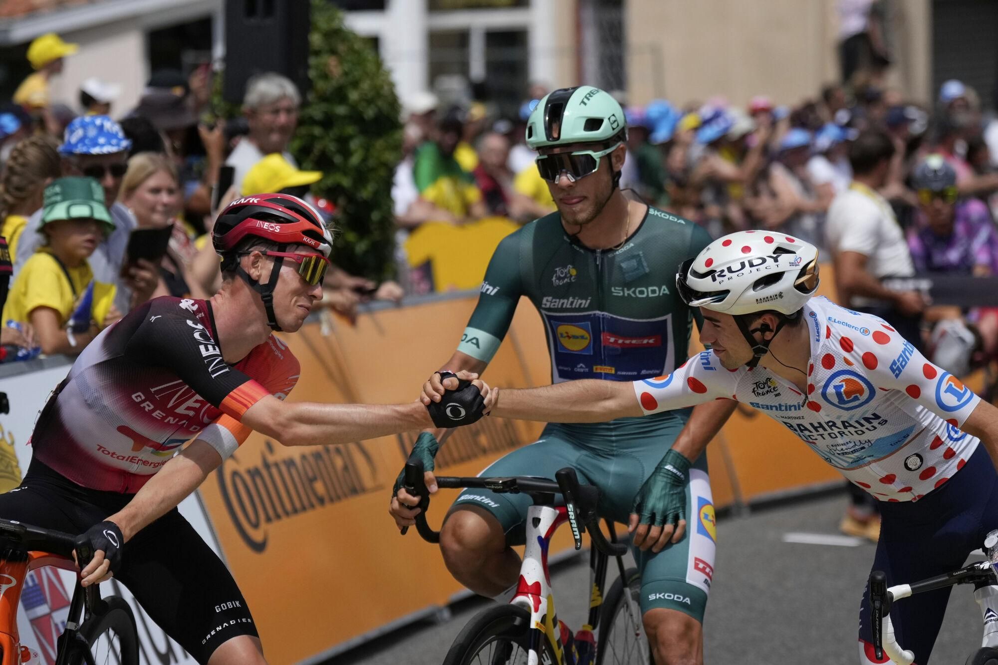 Netherlands' Thymen Arensman, left, and France's Lenny Martinez, wearing the best climber's dotted jersey, greet as Italy's Jonathan Milan, wearing the best sprinter's green jersey, watches prior to the start of the fifteenth stage of the Tour de France cycling race over 169.3 kilometers (105.2 miles) with start in Muret and finish in Carcassone, France, Sunday, July 20, 2025. (AP Photo/Mosa'ab Elshamy)