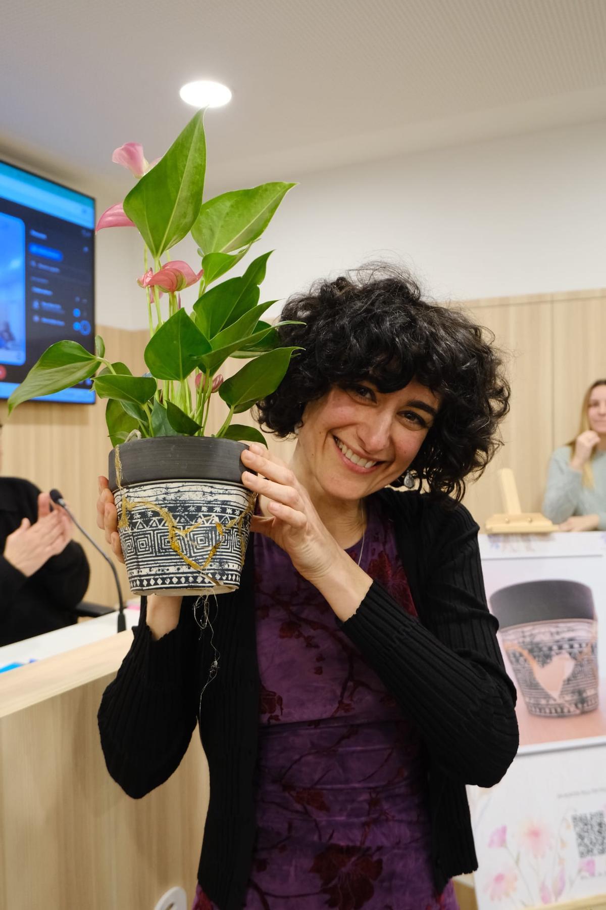 Neus Martí monstrant el test que van reconstruir amb la tècnica Kintsugi, simbolitzant que, tot i venir de l'hivern més dur, es pot tornar a florir.