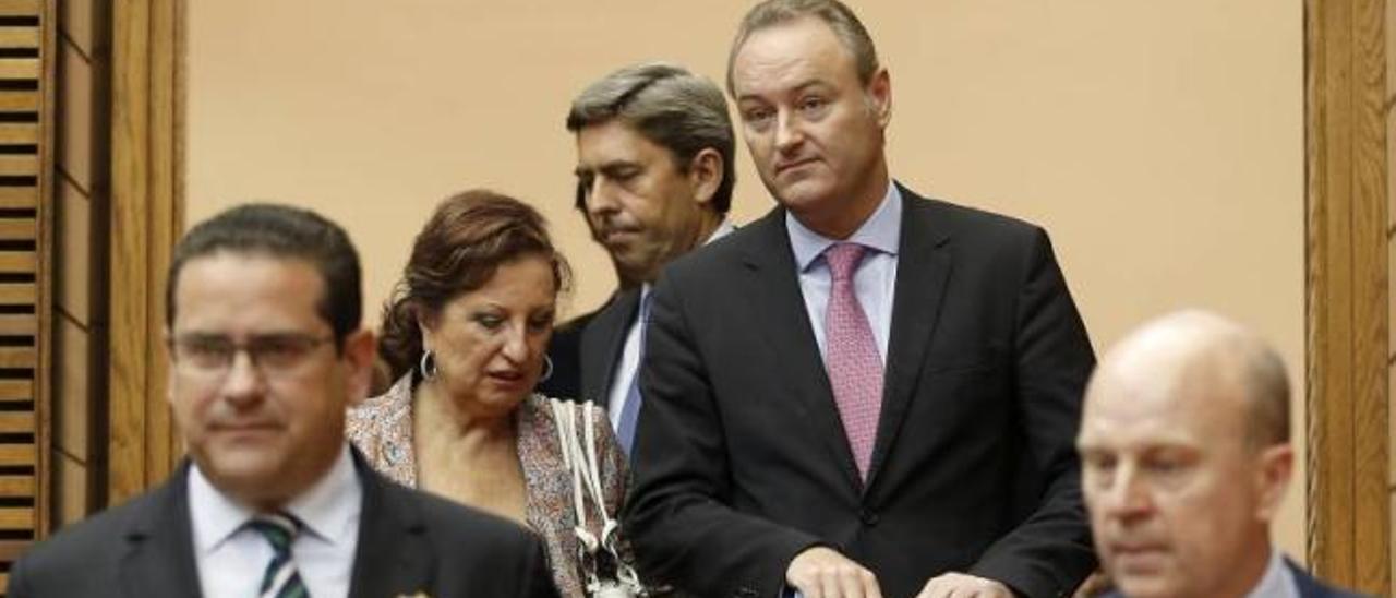 El presidente Alberto Fabra, acompañado por la viceportavoz Marisol Linares, entra en el hemiciclo, con el síndic, Jorge Bellver, en primer plano.
