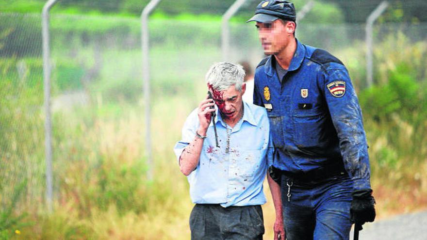 Un policía acompaña al maquinista del tren siniestrado poco después de la tragedia.