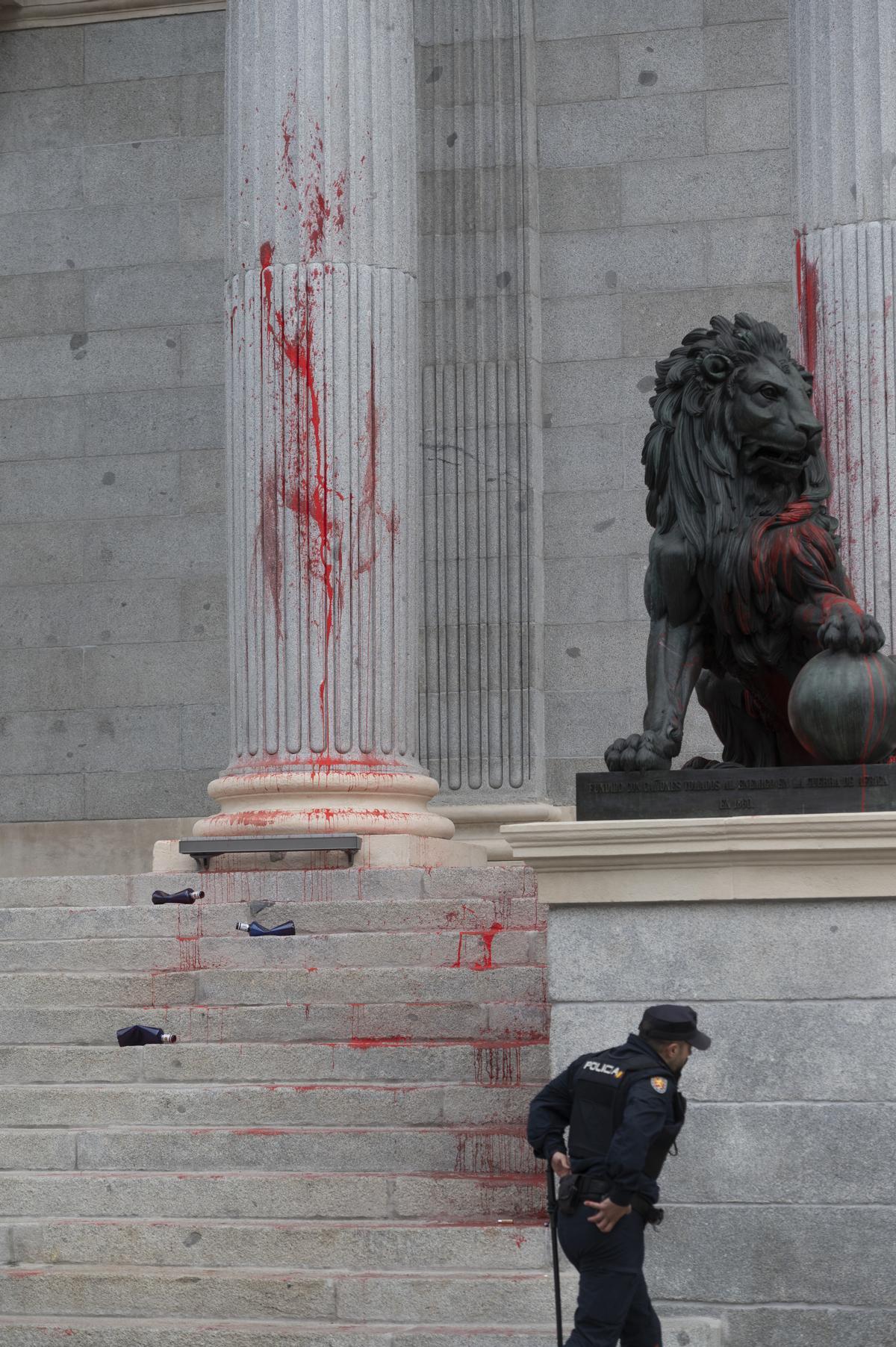 MADRID, 30/03/2023.- Uno de los leones del Congreso, cubierto con pintura roja después de una acción reivindicativa de Rebelión Científica este jueves en Madrid. EFE/ J.J. Guillén