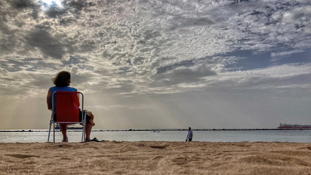 Una mujer en la playa durante un episodio de calima.