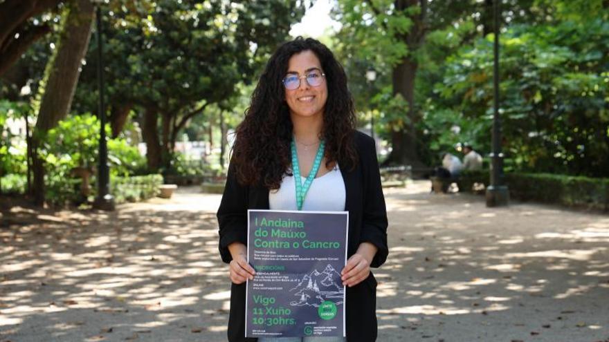 María Gómez, de la AECC de Vigo, con el cartel de la andaina.  | // A. VILLAR