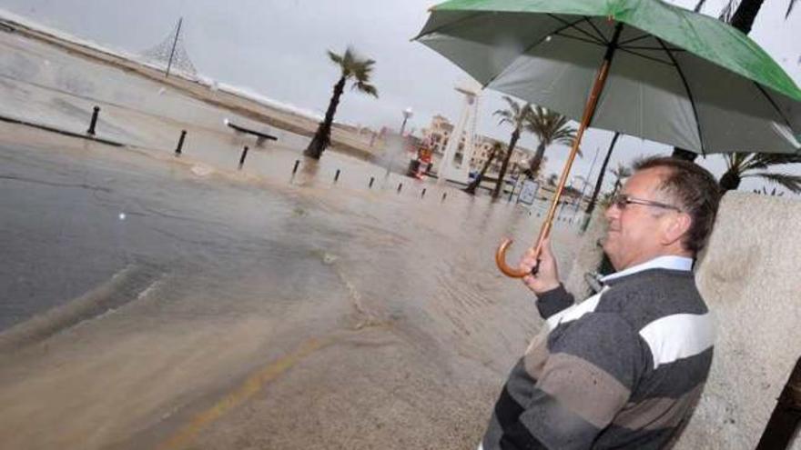 Un vecino de La Zenia comprueba cómo la tromba de agua se confunde con la playa ayer.