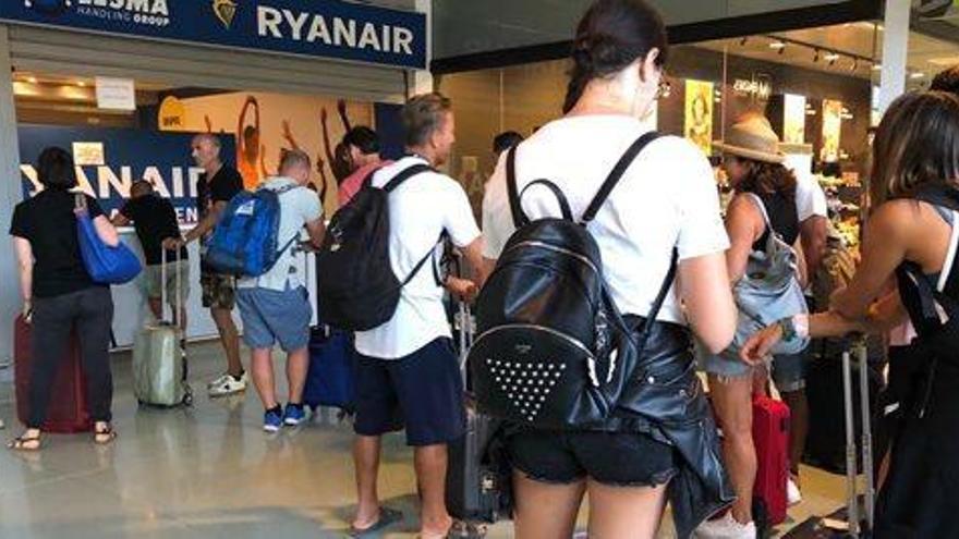 Pasajeros de las salidas suspendidas a Bolonia y Bérgamo buscan otras alternativas a sus vuelos en el mostrador de Ryanair.