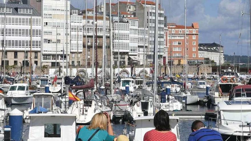 Una familia observa los barcos, desde el banco de la Marina.