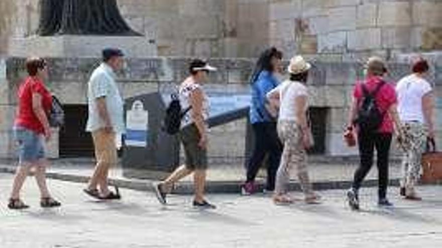 Un grupo de turistas pasea por la Plaza Mayor a pleno sol